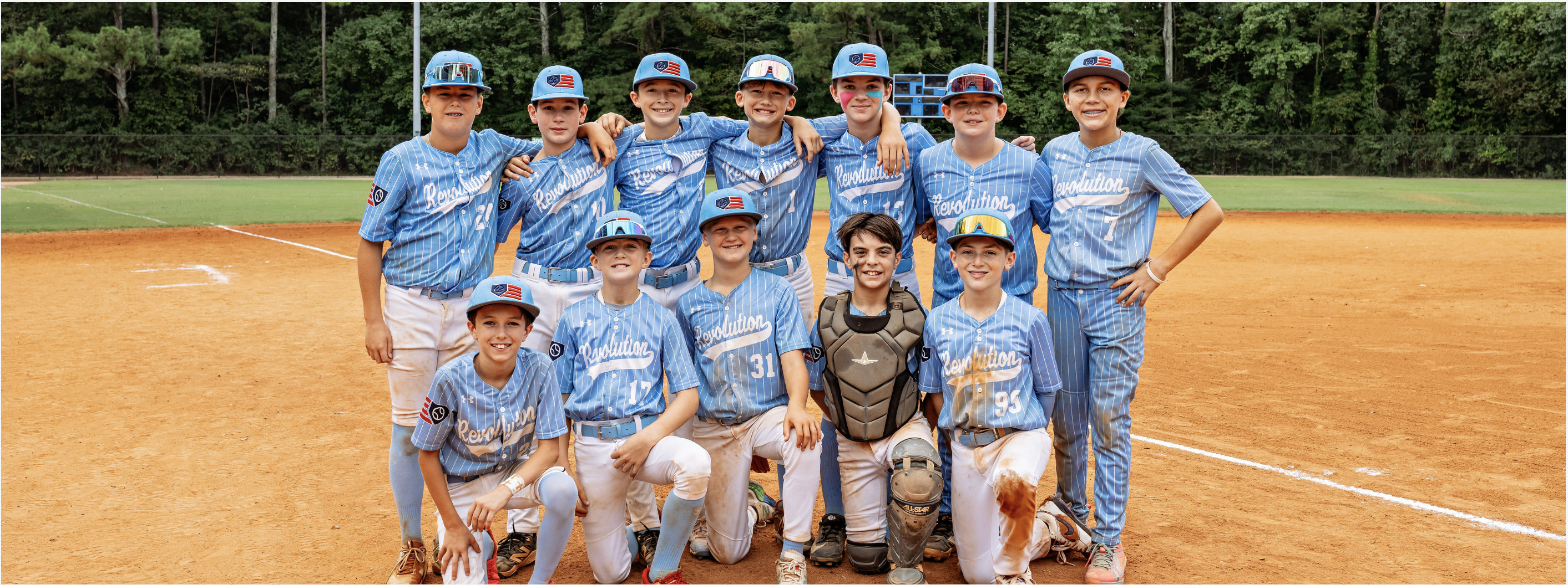 South Charlotte Revolution 12U players in blue pinstripe uniforms pose together on a baseball field.